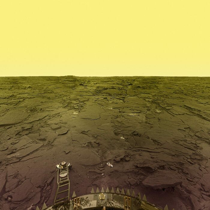 Rough barren terrain under a yellow sky, capturing a beautiful yet unnerving liminal space from a distant perspective.