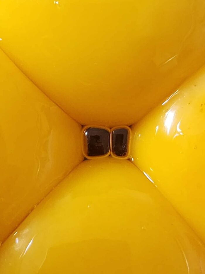 Close-up of a bright yellow liminal space with reflective surfaces creating an unnerving visual effect.