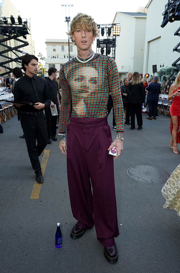 Celebrity wearing a bold, patterned top and wide-legged pants showcasing one of the worst and weirdest celebrity looks.