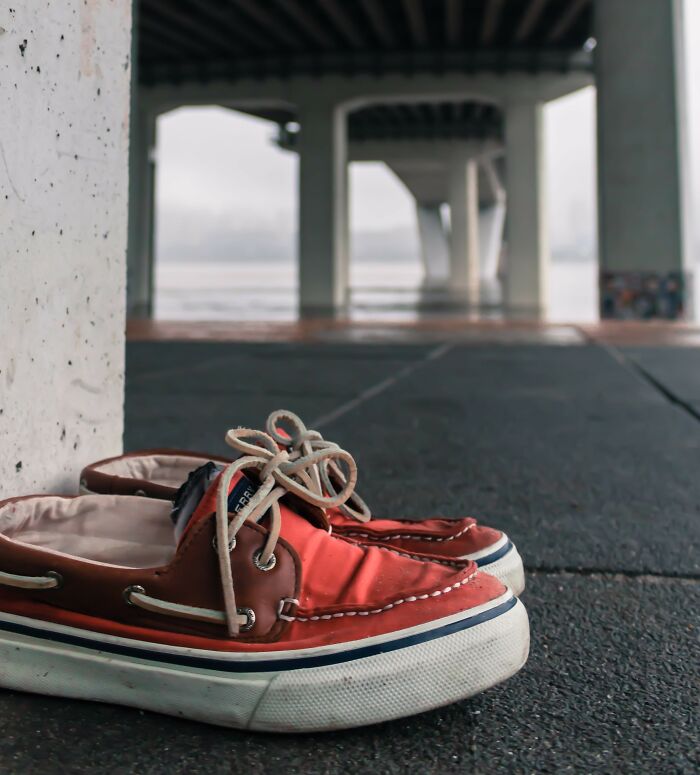 A pair of red boat shoes left alone under a bridge, creating a creepy photo moment that makes hearts skip a beat.
