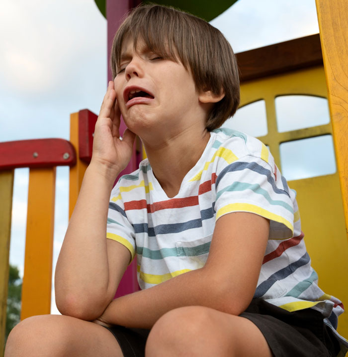 Crying boy upset on colorful playground equipment, illustrating teen refuses to entertain stranger&rsquo;s kid on flight.