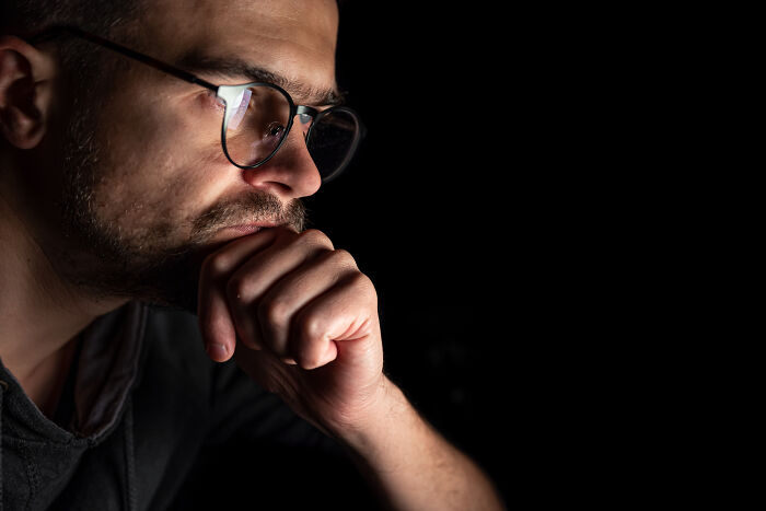 Man wearing glasses, deep in thought, illustrating the theme of mysteries that once baffled the world but are now solved.