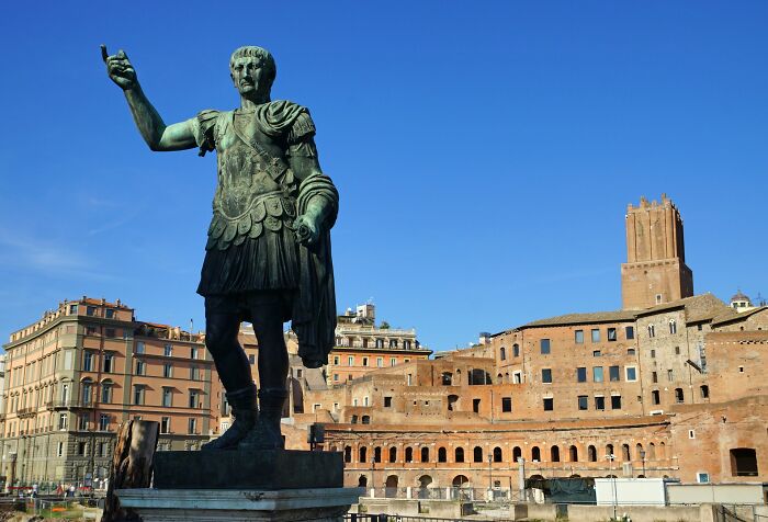 Statue of a Roman emperor with ancient ruins and historic buildings, showcasing unbelievable facts about countries.