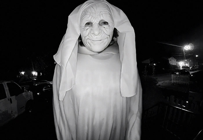 Masked figure in eerie costume captured at night during disturbing doorbell prank with a staggering twist revealed later.