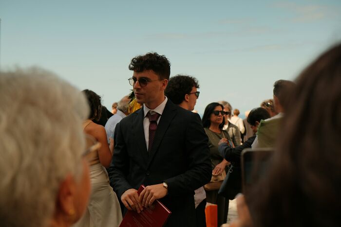 Man in sunglasses and black suit at an outdoor event, representing an innocent worker in a boss wife affair claim scenario.