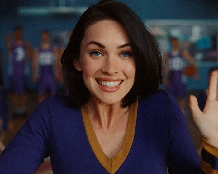 Megan Fox smiling in a purple and gold outfit, sparking plastic surgery speculation after her latest red carpet appearance