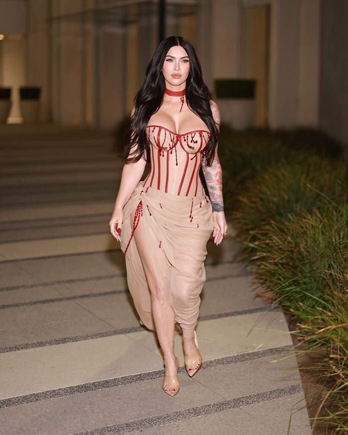 Megan Fox wearing a sheer beige and red dress on the red carpet sparking plastic surgery speculation.