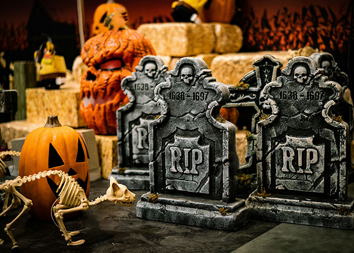 Halloween-themed spooky graveyard scene with tombstones and a pumpkin skeleton, capturing socially awkward situations humor.