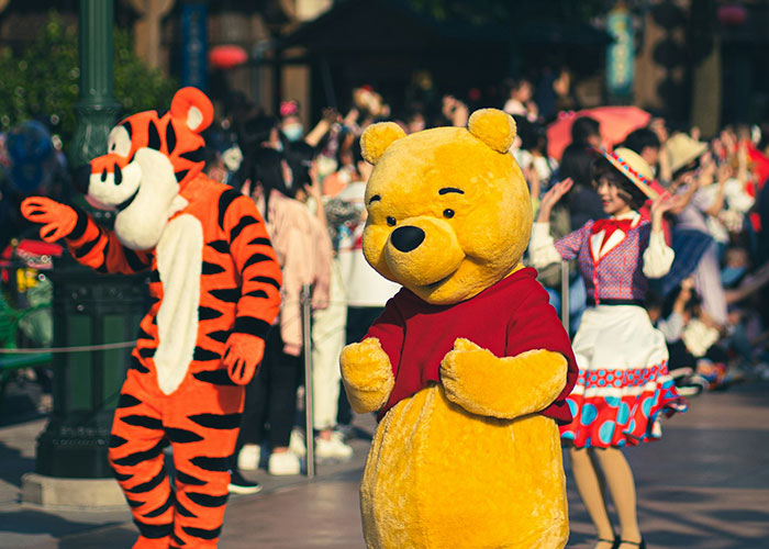 Two people in character costumes with a crowd in the background, capturing socially awkward situations in public.