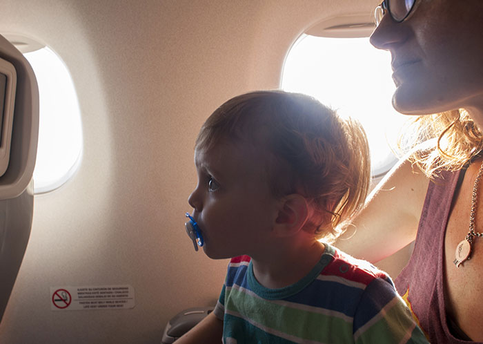Toddler meltdown on plane with mom nearby and passenger confronting her about handling the situation during flight.