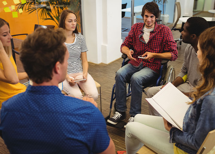 Group therapy session with diverse young adults discussing emotions, reflecting on mom admits she likes one daughter more struggles.