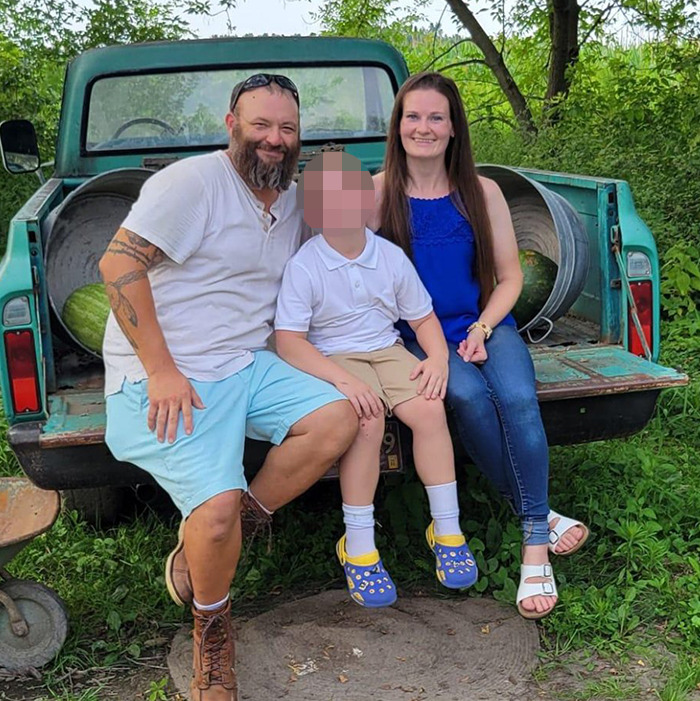 Family sitting on the back of a truck in a green outdoor area, related to Mormons raising money controversy.