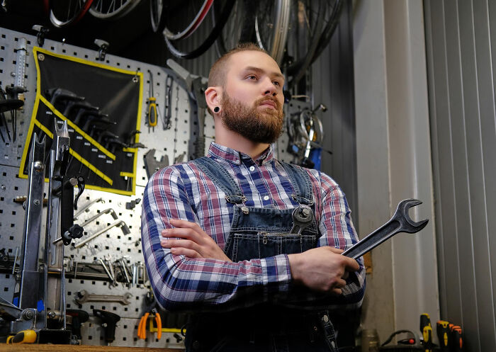 Mechanic holding a wrench in a workshop, symbolizing multilinguals catching folks gossiping in secret languages they understood.