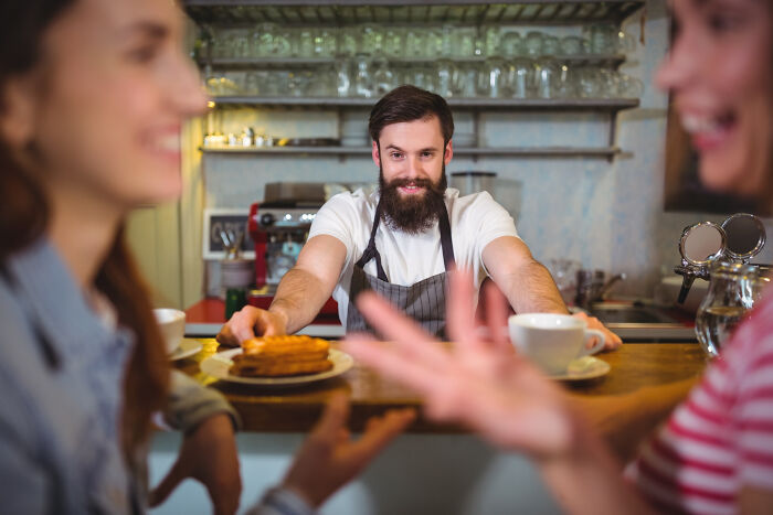 Barista serving coffee while two multilingual people catch gossip in secret languages they understood perfectly.
