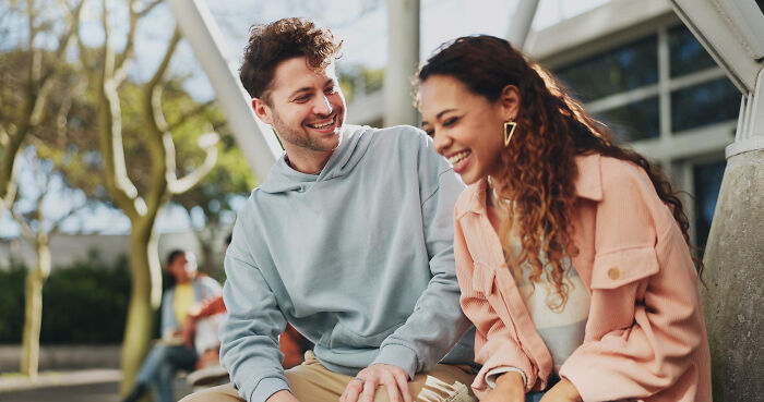 Two multilingual friends sitting outdoors, smiling and catching gossip in secret languages they understood perfectly.