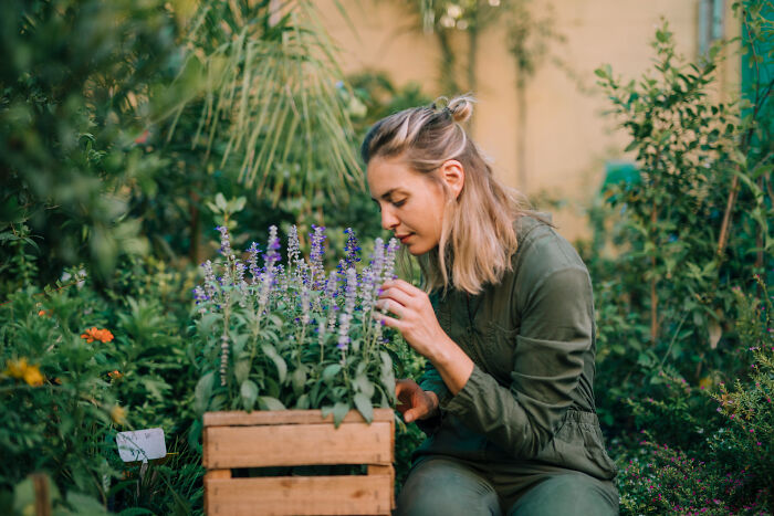 Young woman in garden tending to flowers, illustrating multilinguals catching folks gossiping in secret languages concept.