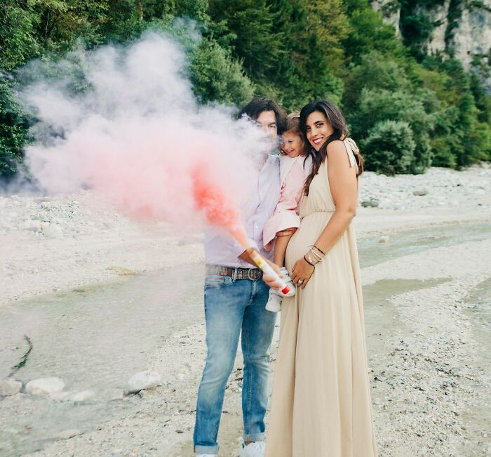 Family celebrating outdoors with pink smoke, illustrating wedding guests making the bride and groom regret knowing them.