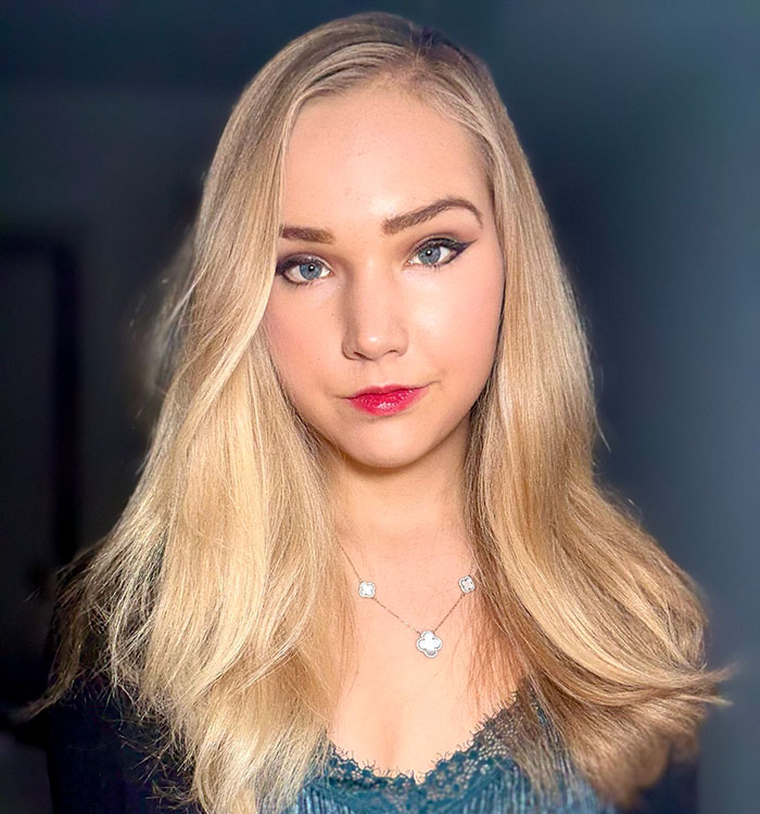 Young German activist known as Anti-Greta, with long blonde hair, looking at camera in a softly lit indoor setting.