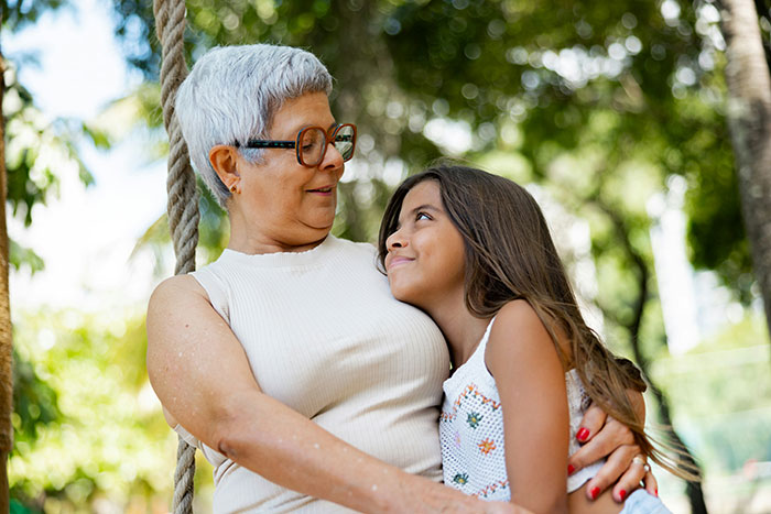 Older woman and young girl sharing a tender moment outdoors, illustrating toxic in-laws banned from visiting their newborn.