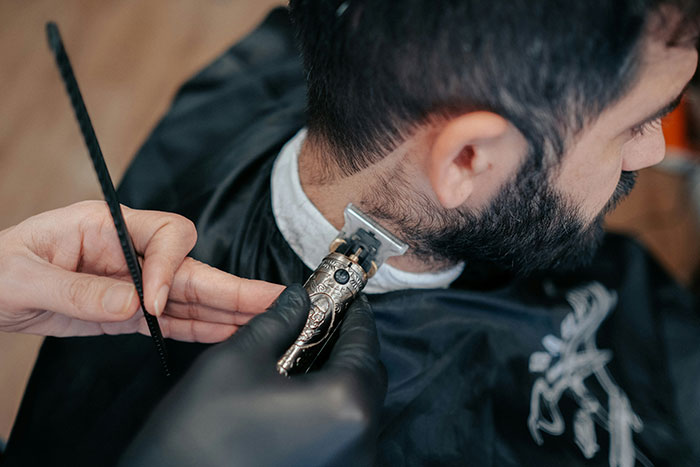 Man getting a close haircut at a barbershop, illustrating subtle red flags women didn’t realize in relationships.