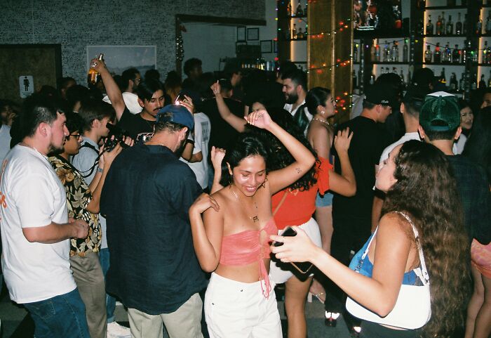 Group of people dancing and socializing at a crowded party, illustrating surprising answers from Americans in real life.