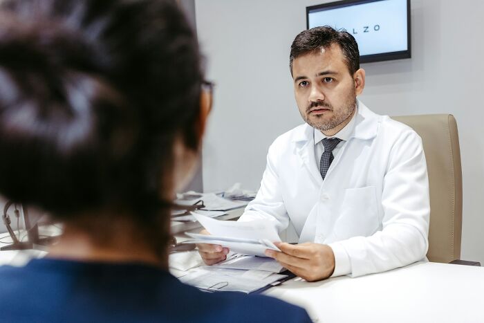 Man in white coat answering questions from woman during a real-life consultation with surprising answers about common beliefs
