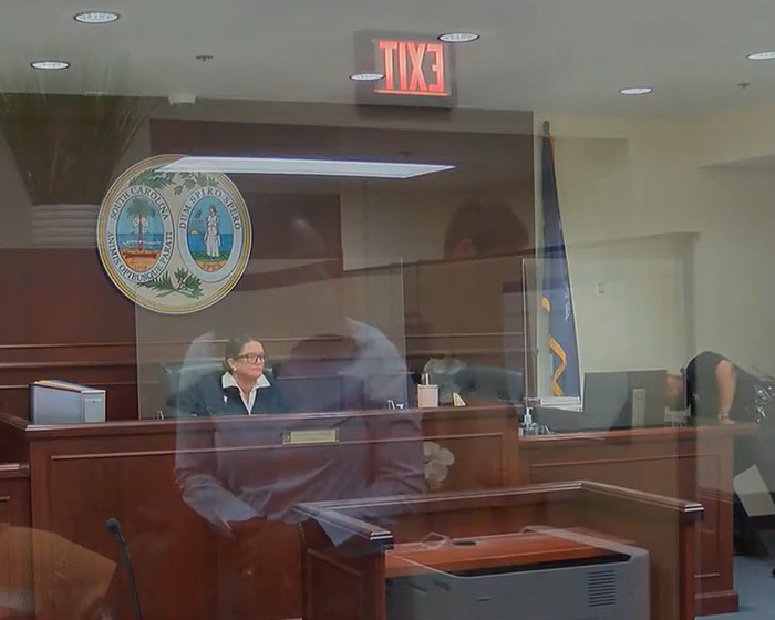 Courtroom scene with a judge presiding over a case involving an 82-year-old woman and handwritten notes evidence.