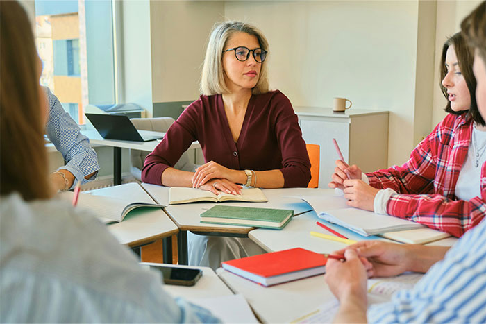 A group of young people having a discussion with notebooks and pens, showcasing clueless things young people said.