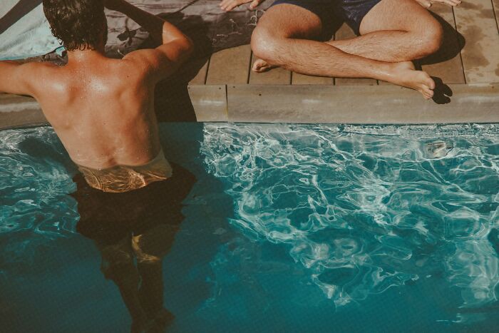 Two individuals by a pool, one sitting on the edge and the other in the water, representing near-death experiences.