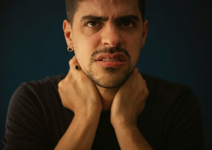 Close-up portrait of serious man in suit and red tie, representing disappointment in someone people idolized.