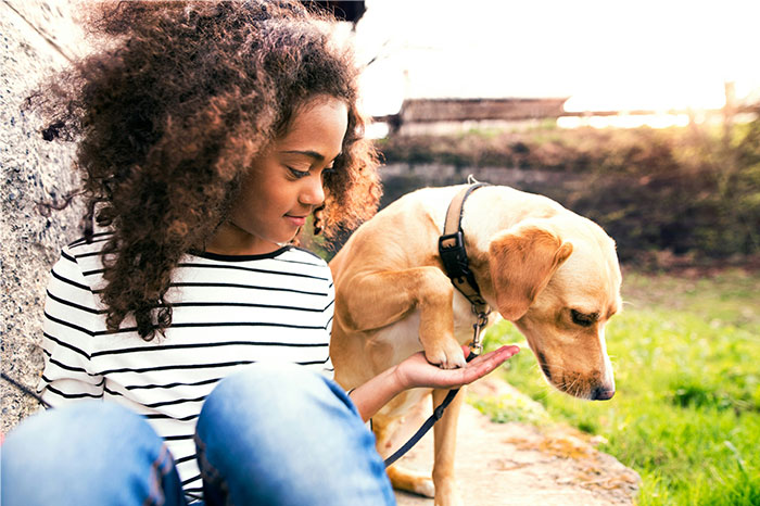Young woman outdoors with her dog, illustrating parents sharing baby names they regret giving to their kids.