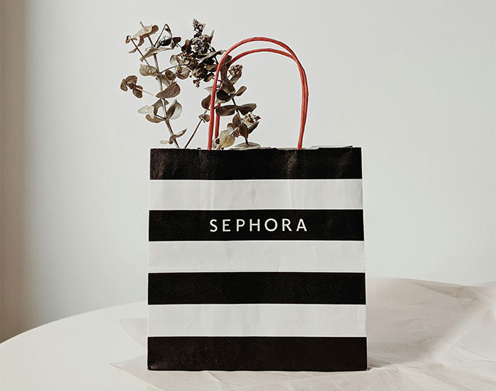 Striped Sephora shopping bag with dried flowers inside, illustrating parents sharing baby names they regret.