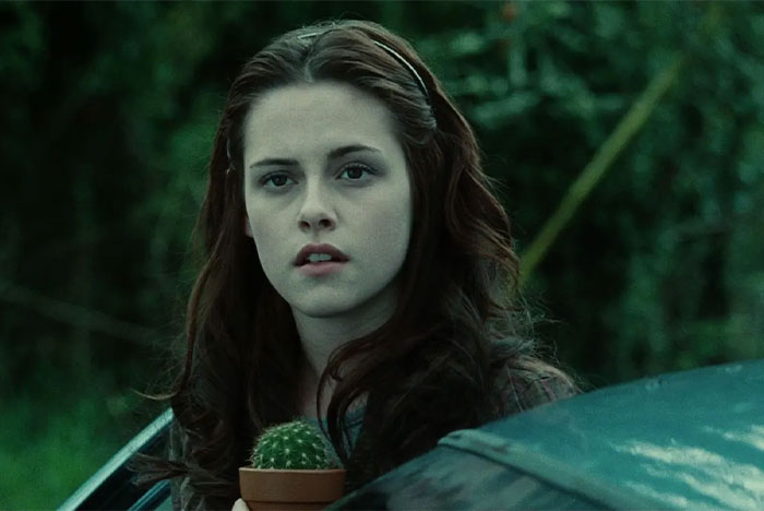 Young woman holding a small cactus plant outdoors, illustrating parents sharing baby names they regret giving.