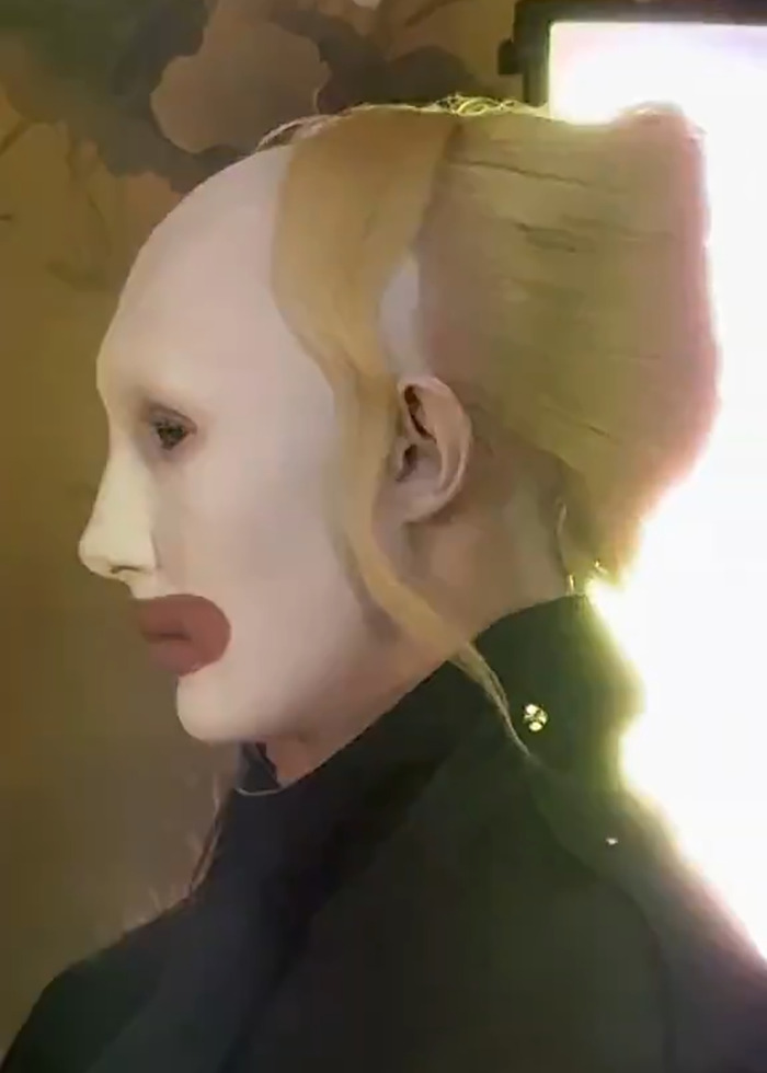 Model with avant-garde makeup and hairstyle showcasing boundary-breaking Paris Fashion Week look inspired by Hunger Games.