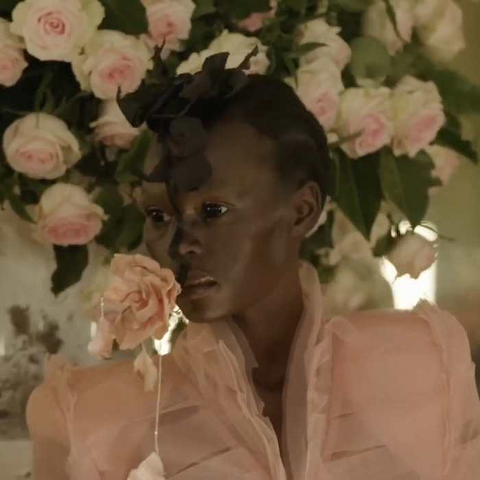 Model in sheer pink attire with dramatic floral headpiece, reflecting Paris Fashion Week's boundary-breaking Hunger Games vibe.