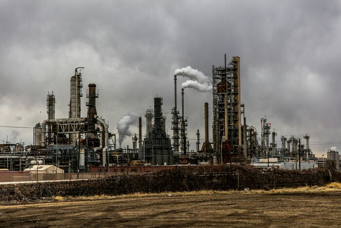 Industrial refinery with smoke emissions under a cloudy sky, symbolizing common truths people were fooled into believing.