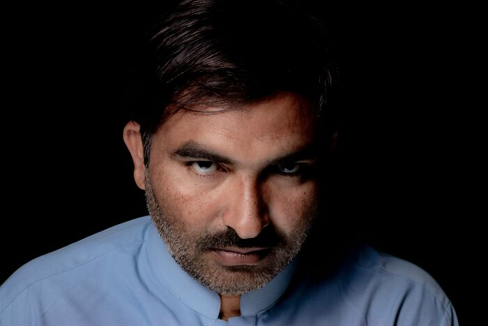 Man with intense expression in low light, representing emotional cruelty and relationship distress themes.