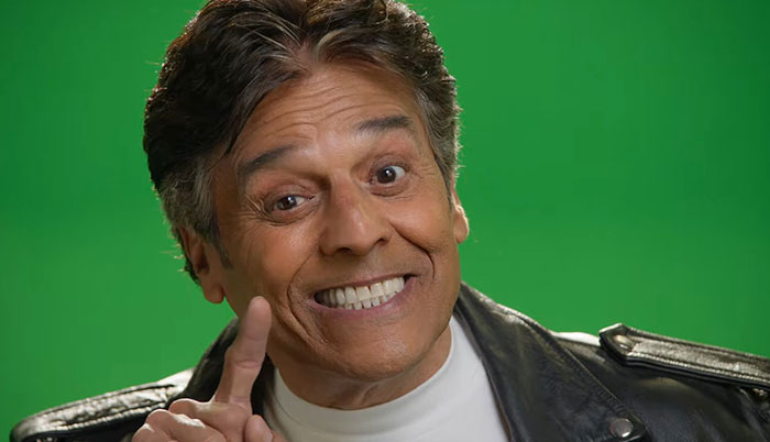 Man smiling and pointing upward against a green background, illustrating people sharing their encounters with celebrities.