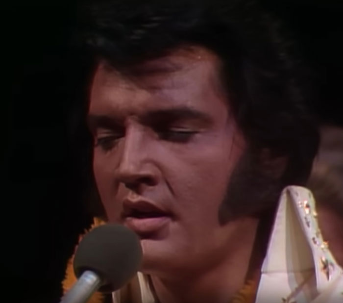 Close-up of a celebrity singing into a microphone during a live performance, capturing a memorable celebrity encounter.