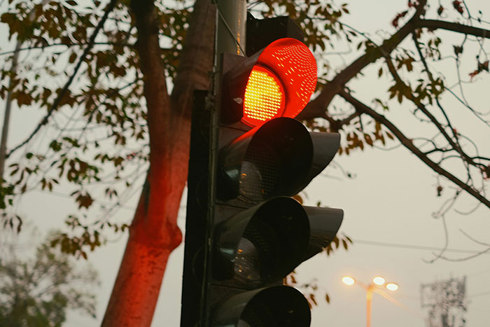Red traffic light glowing against a dusky sky symbolizing how to ruin your entire life by ignoring warnings.