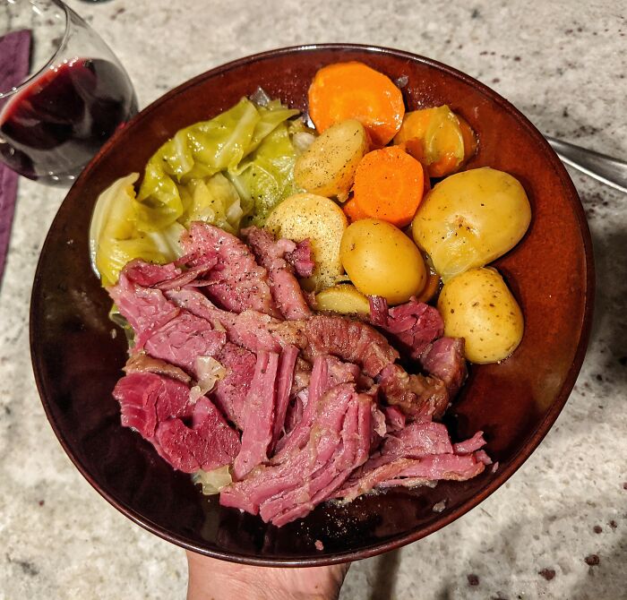 A bowl of traditional corned beef with potatoes, carrots, and cabbage, illustrating foods not popular in their country.