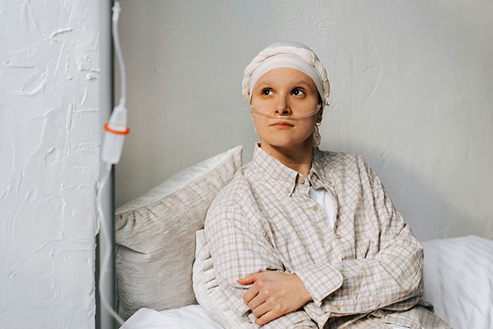 Young patient wearing oxygen tube and head wrap, resting in bed, illustrating nightmare situations people survived.