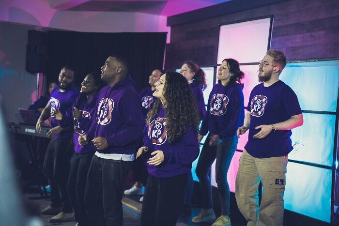 Group of diverse young adults wearing matching hoodies engaging in a joyful activity reflecting childhood rules and therapy themes.