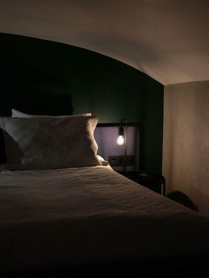 Dimly lit bedroom with a single bed and pillow, highlighting cozy childhood rules from a therapist’s perspective.