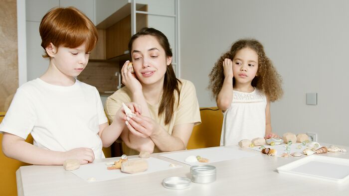 Mother and children engaged in a childhood activity at home, illustrating childhood rules and family bonding time.