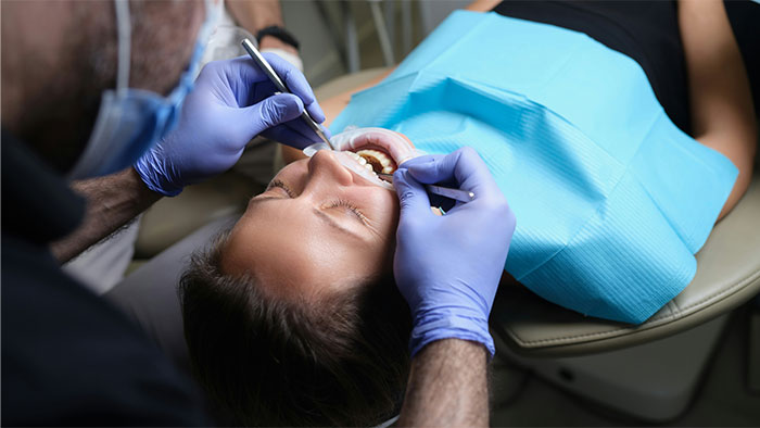 Patient undergoing dental surgery with a dentist performing procedure, illustrating bone-chilling surgery stories.