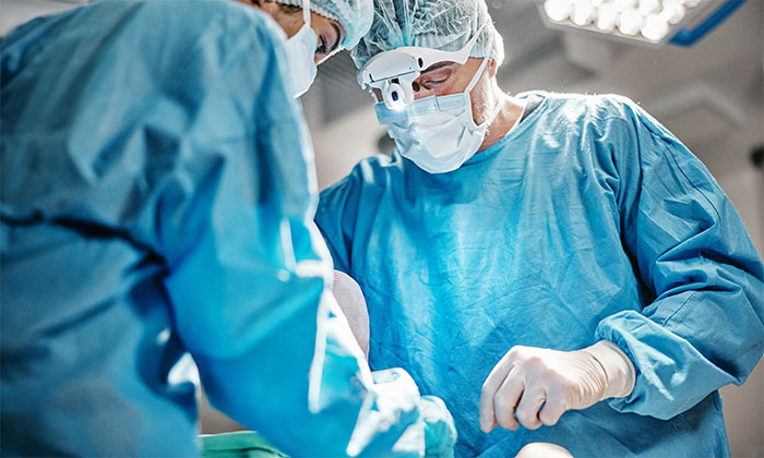 Surgeons in blue scrubs performing a procedure highlighting stories of patients waking up during surgery.
