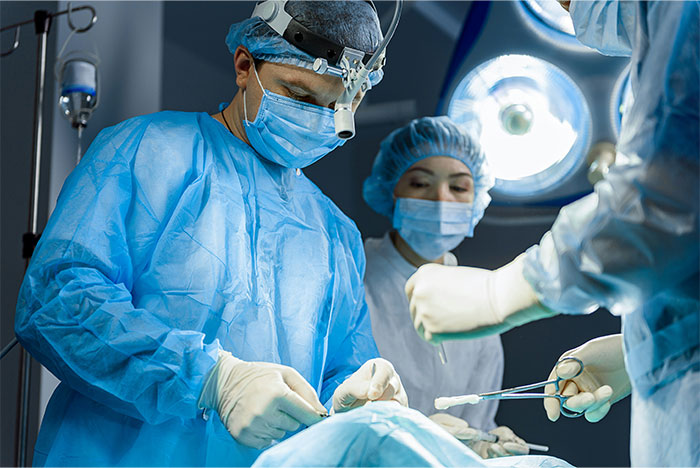 Surgeons in blue scrubs performing an operation, highlighting bone-chilling and hilarious surgery stories.