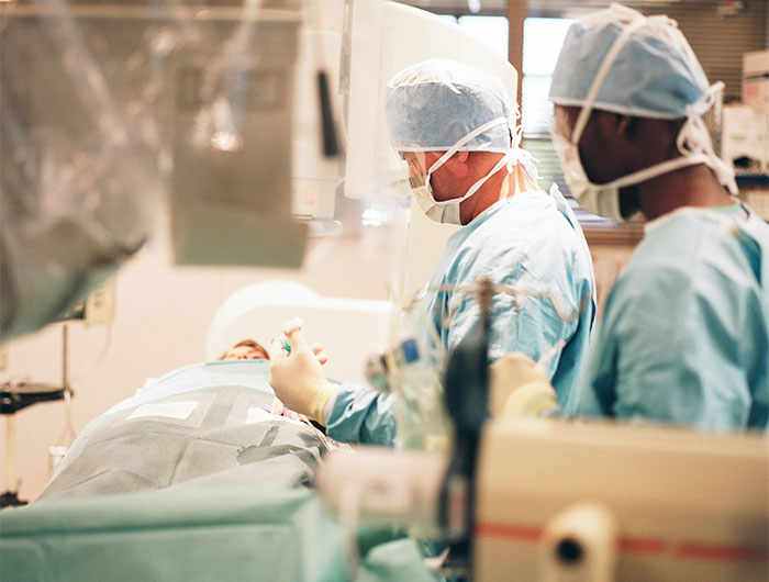 Two surgeons in operating room performing surgery with patient under anesthesia, highlighting bone-chilling surgery stories.