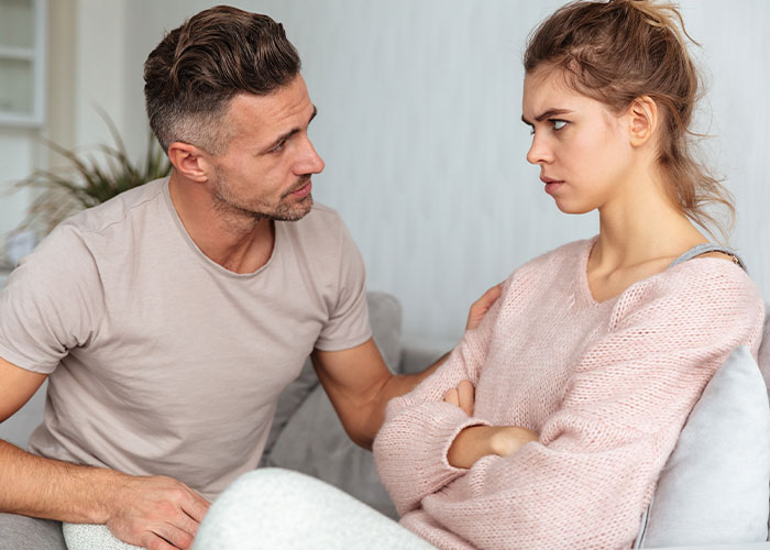 Man trying to comfort upset woman during serious conversation, illustrating how to ruin your life with real sobering stories online.